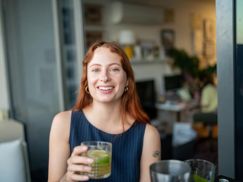 woman smiling with homemade cocktail